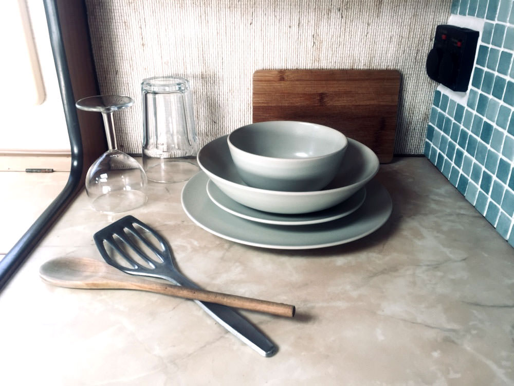 Zero Waste Camper: Gläser, Teller und etwas Kochbesteck liegen auf der Küchenarbeitsplatte