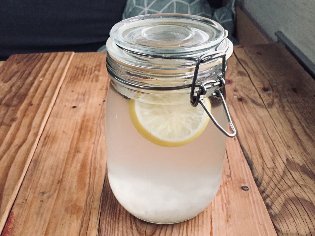 Zero Waste Küche: Ein Bügelglas gefüllt mit einer weißlichen Flüssigkeit und einer Zitronenscheibe.